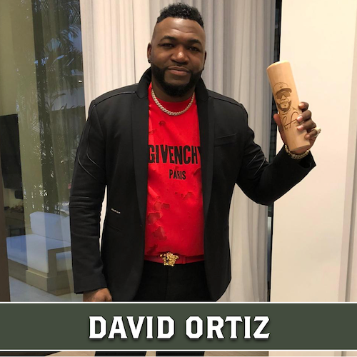 David Ortiz holding up a wooden Dugout Mugs baseball bat mug.